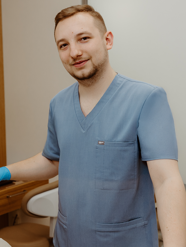 Lekarz dentysta Daniel Malicki w gabinecie stomatologicznym podczas pracy z pacjentami